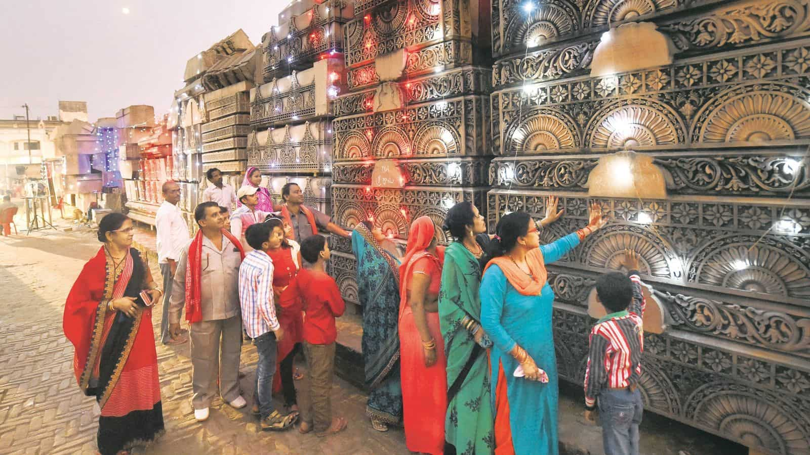 अयोध्या राम मंदिर निर्माण कार्य देखते श्रद्धालु.