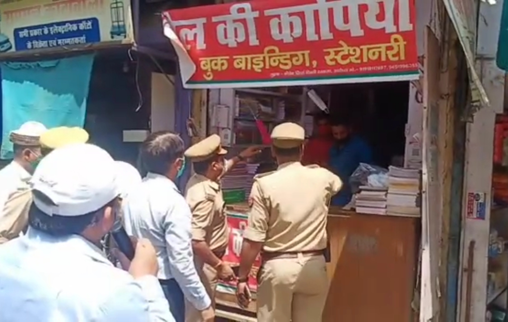 दुकानदारों को समझाती पुलिस