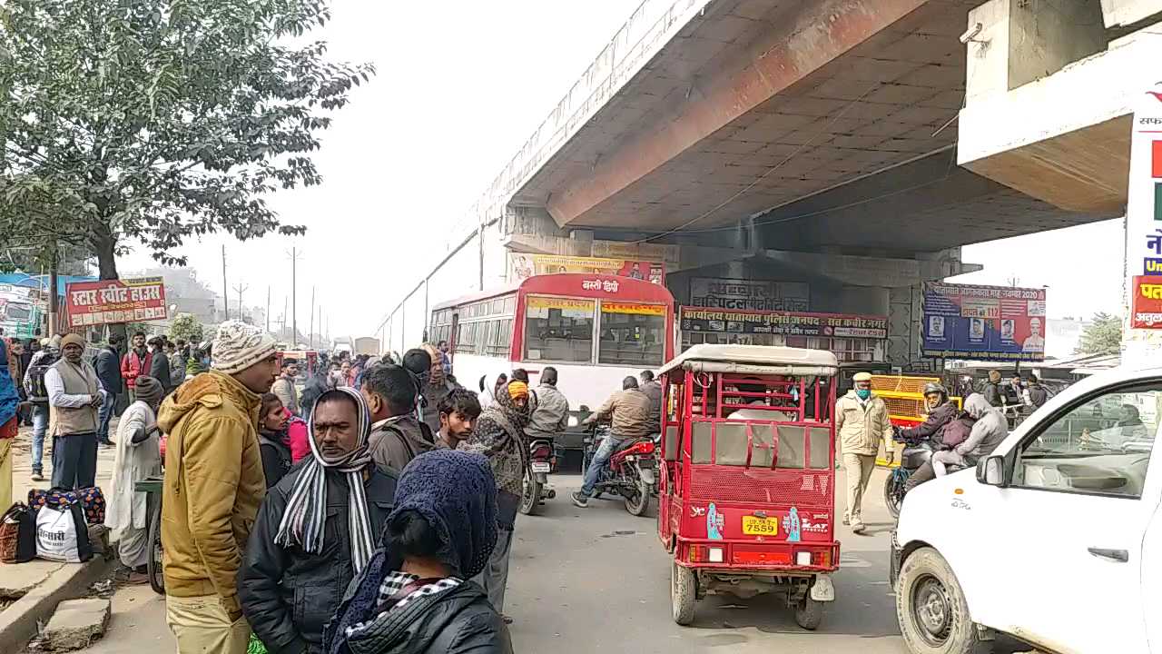 रोड किनारे बस का इंतजार करते यात्री.