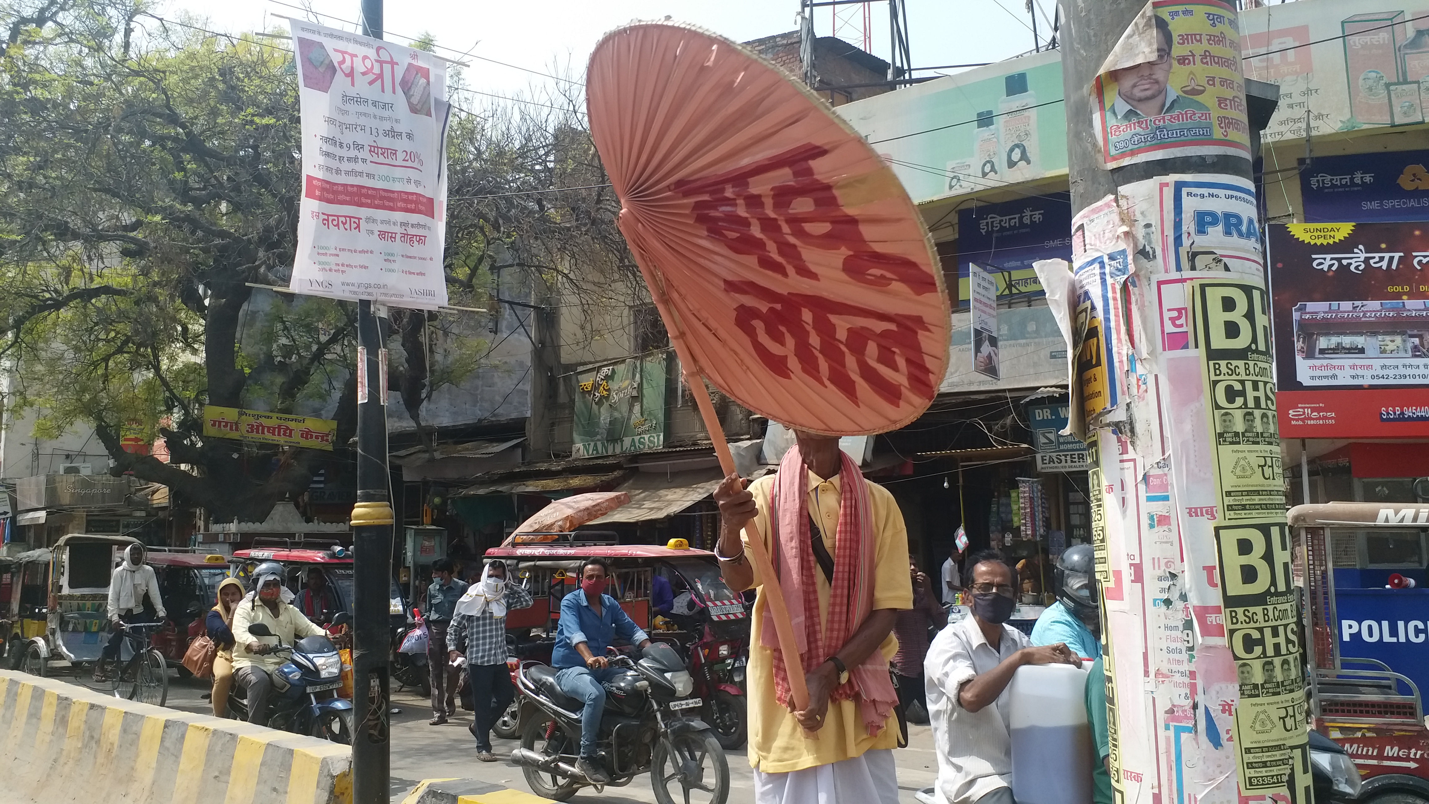 चौराहे पर पंखा लिये खड़े बाबूलाल.