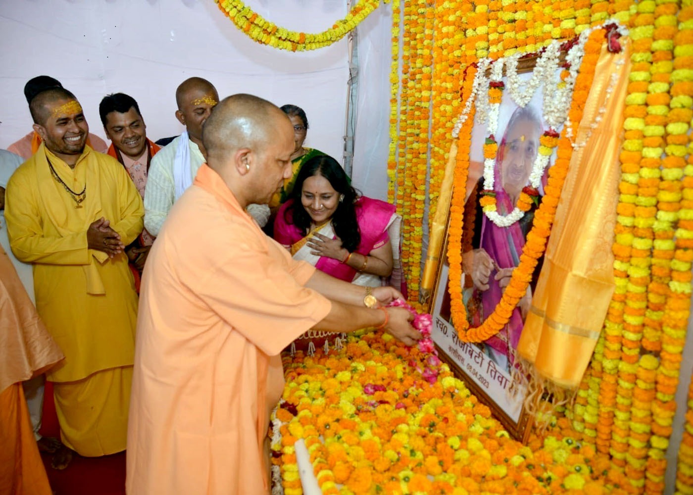 महामंडलेश्वर संतोष दास महाराज की माता जी के चित्र पर पुष्प अर्पित करते सीएम योगी