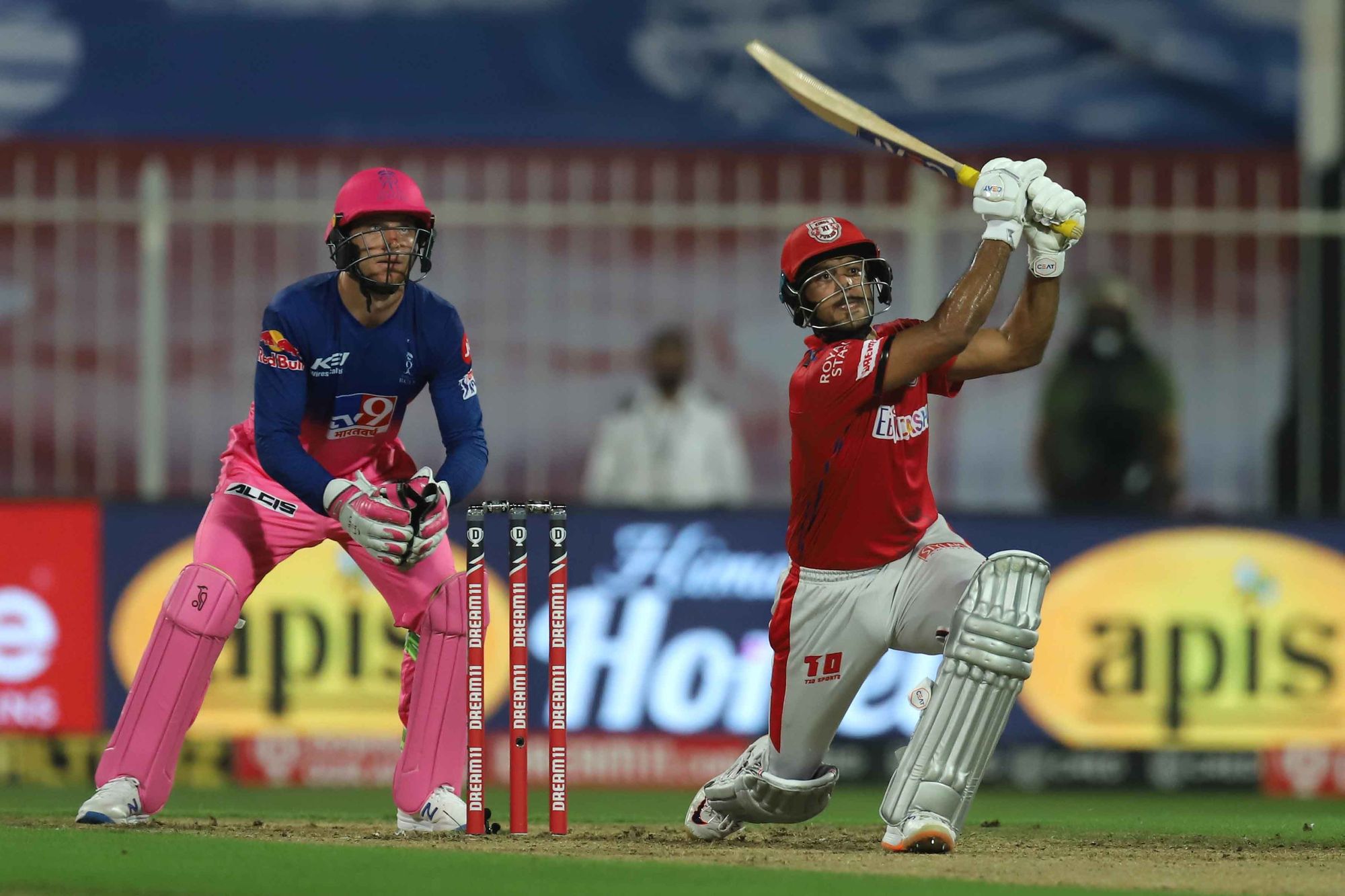 Mayank Agarwal playing shot as RR wicket-keeper Jos Buttler looks on.