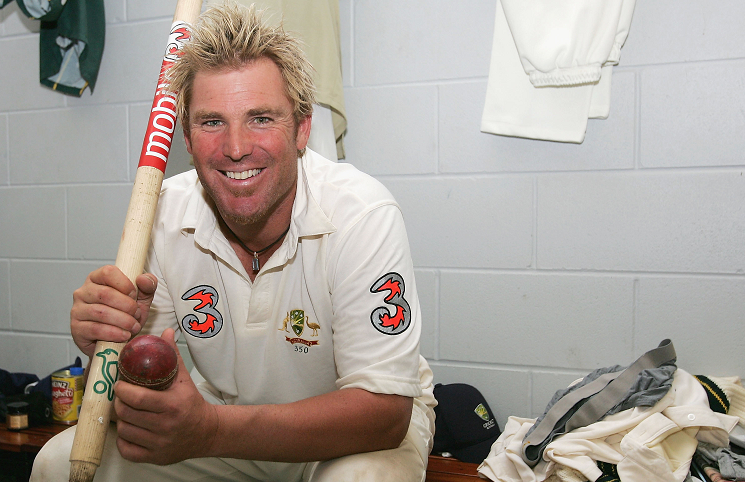 Shane Warne at the dressing room with the ball and wicket after reaching the milestone.