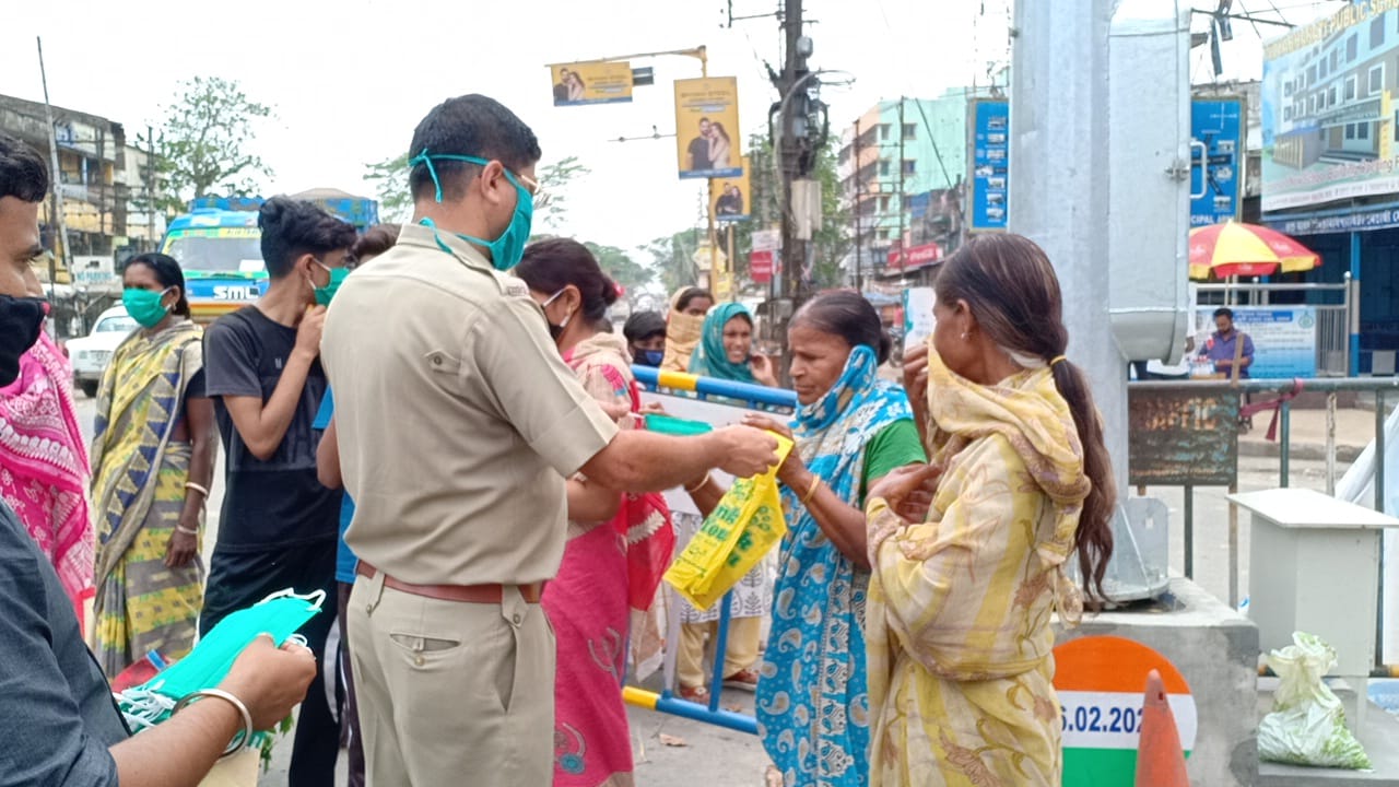 মহিলাদের হাতে মাস্ক তুলে দিচ্ছে পুলিশ