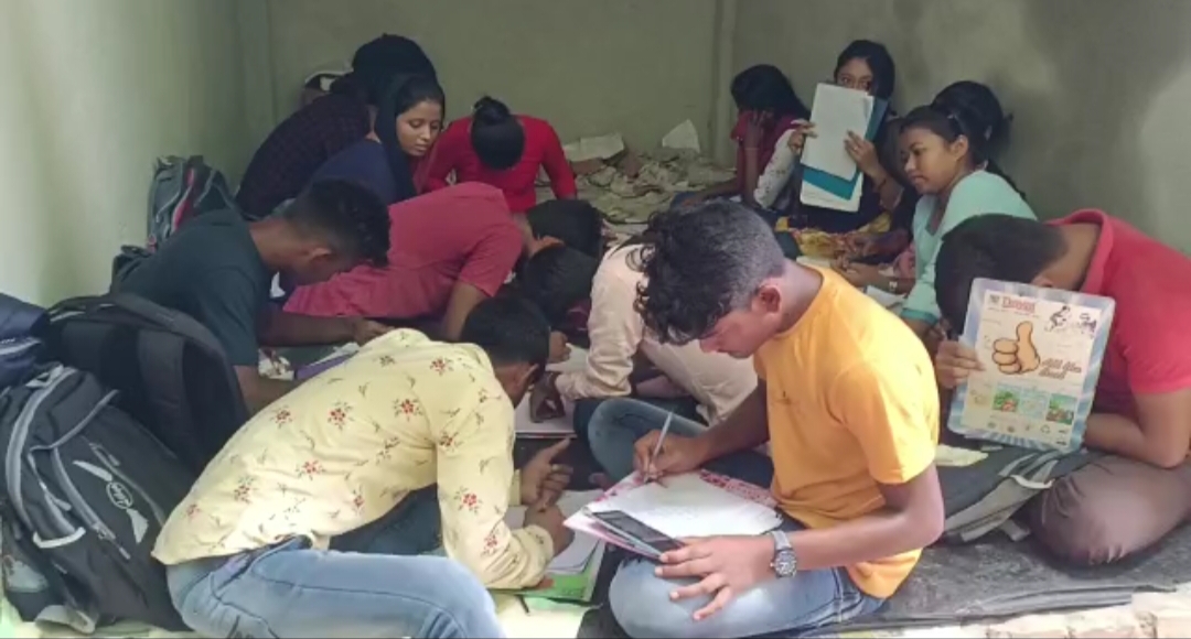 Students writing answer sheet seeing mobile or book in Surendranath College at Raiganj